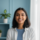 Portrait of a smiling South Asian woman in her late 20s, looking at the camera with a happy expression.